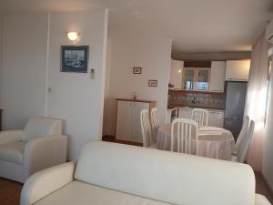 a living room with a table and a kitchen at Apartments Villa Eden in Preko
