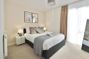 a bedroom with a large bed and a window at Modern 2 Bedroom Apartment Steps from Vauxhall St in London