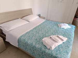 a bedroom with a bed with two towels on it at La segreteria in Acireale