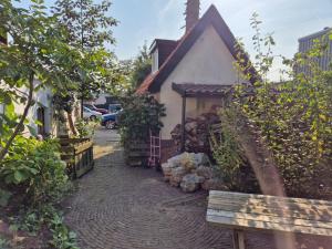 a small house with a brick path next to a building at Rustiek authentiek Bakhuisje in Rijsenburg