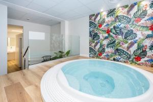 a jacuzzi tub in a room with a mural at Comitas Floramar in Cala Galdana