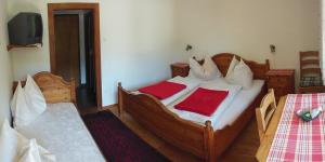a bedroom with two beds with red sheets and a tv at Jörghof in Bad Kleinkirchheim