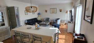 a living room with a table with chairs and a living room at Maison proche plage et commerces in Pénestin