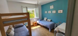 a bedroom with two bunk beds and a window at Maison proche plage et commerces in Pénestin