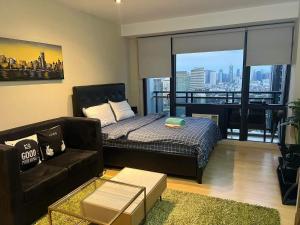 マニラにあるStaycation Fully Furnishedのベッドとソファのあるリビングルーム
