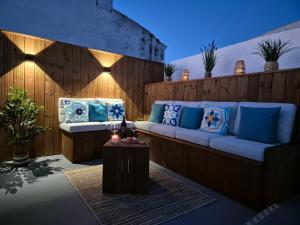 a patio with a blue couch and a table at Pêra Holiday House in Pêra