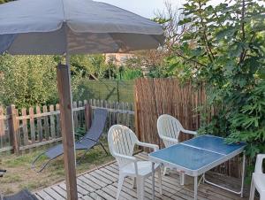 a table and chairs and an umbrella on a deck at Maison de ville avec jardin-Rêve à Rixheim! in Rixheim