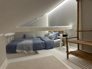 a bedroom with a bed with blue comforter at Miniluksus loma-asunto & parveke puuvillassa HUVILAPUISTOSSA in Hanko