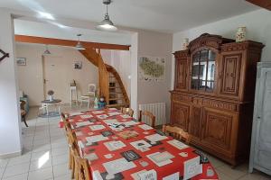 a dining room with a table and a wooden cabinet at Maison avec cour fermée in Gratibus