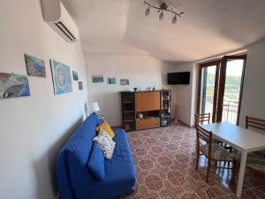 a living room with a blue couch and a table at Casa Anteresa in Vietri sul Mare