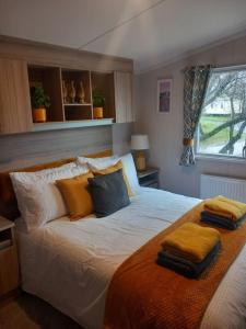 a bedroom with a large bed with pillows on it at Nadia's Lodge Smart TV & Wi-Fi in Haverigg