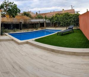 a swimming pool with a bench in a yard at La Cabane des Mouts- Piscine -Clim in Fleury