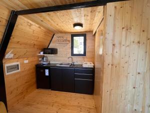 a kitchen in a log cabin with a sink at Moobs Sunset Cabins in Batroûn