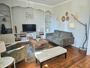a living room with a couch and a tv at Les bois flottés in La Richardais