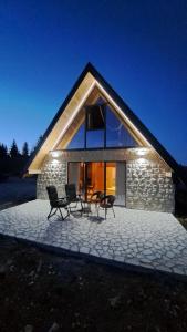 une maison avec des chaises et une table devant elle dans l'établissement Monntana Zabljak, à Žabljak