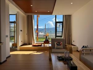 un soggiorno con un divano e una grande finestra di 茨姆极光民宿 a Shangri-La