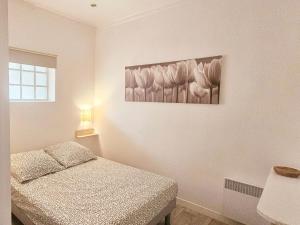 a bedroom with a bed and a painting on the wall at Les bois flottés in La Richardais