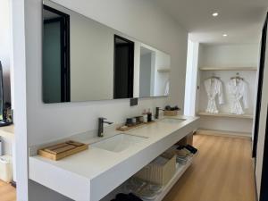 un bagno bianco con lavandino e specchio di 茨姆极光民宿 a Shangri-La