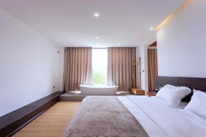 una camera da letto con un letto grande e una vasca da bagno di 茨姆极光民宿 a Shangri-La