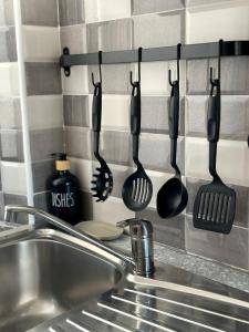 un gruppo di utensili appesi a una parete sopra un lavandino di Dimora La perla di Mare a Termoli