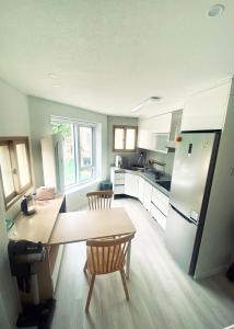 a kitchen with a table and a refrigerator at Kelly House in Goyang +11 photos