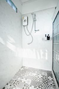 a shower in a white bathroom with a tile floor at Bang Mee Homestay Koh Yao Noi in Ko Yao Noi +90 photos