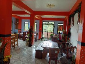 a dining room with red walls and tables and chairs at Banaue Greenfields Inn and Restaurant in Banaue +24 photos