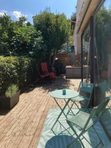 米洛Chambre dans villa cosy avec terrasse的露台设有桌子和两把椅子,位于甲板上