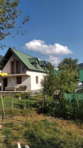 a white house with a green roof at Vikendica Veruša in Veruša