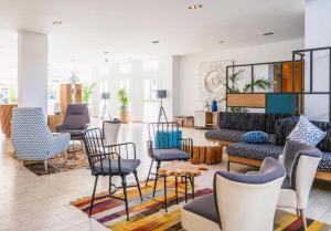a lobby with chairs and tables and a couch at Grupotel Rocador - Adults Only in Cala d´Or
