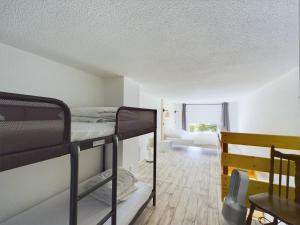 a room with two bunk beds and a bedroom at À 150m de la plage, appartement mezzanine pour 4 in Les Bussolleries