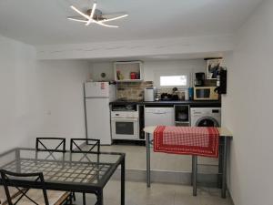 a kitchen with a table and a ceiling fan at Maison 47m2 à 800 m de la plage in Saint-Raphaël +3 photos