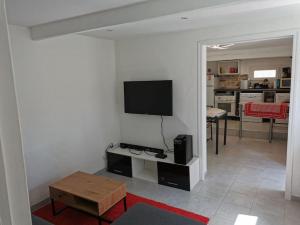 a living room with a flat screen tv on a wall at Maison 47m2 à 800 m de la plage in Saint-Raphaël
