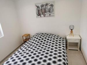 a bedroom with a black and white bed and a table at Maison 47m2 à 800 m de la plage in Saint-Raphaël