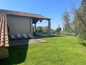 a gazebo with two lounge chairs on a lawn at Villaimmersanellecollinetoscane in Pescia Romana