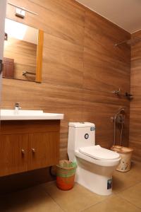 Un baño con inodoro, lavabo y espejo. en Spring Field Billets, en Kochi