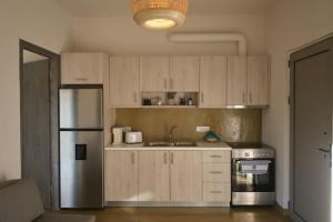 a kitchen with wooden cabinets and a stainless steel refrigerator at Mekia's beach house in Livadia