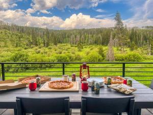 a table with two pizzas on it with a view at Rock n Stars Chalet townhouse in Hideaway Park