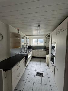 a kitchen with white cabinets and a black counter top at Täles Monteur Quartier in Deggingen