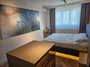 a bedroom with a bed and a painting on the wall at Apartament Concept 4 You in Târgu-Mureş