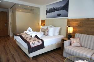 Łóżko lub łóżka w pokoju w obiekcie Hotel Alpenkönigin - Sommer Silvretta Premium Card inklusive