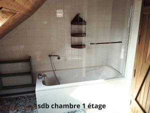 a bath tub with a glass door in a bathroom at la longère du plessis Mornay, 30 min du Puy du fo, wifi, parking, jardin in La Forêt-sur-Sèvre +15 photos