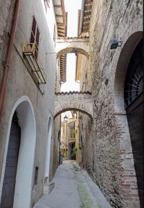 ベヴァーニャにあるCasa degli Zii, relax a Bevagna AC e zanzariereの古石造りの建物内のアーチのある路地