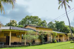 an old yellow house with a palm tree at Rivendell Twisted Tree in Kurunegala