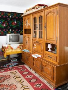 a wooden cabinet with a tv in a room at Casuta bunicilor in Volovăţ