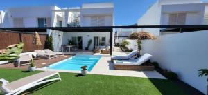 a backyard with a swimming pool and a house at Serena Holiday Homes by LIVVO in Playa Blanca