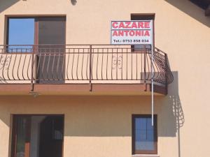 阿尔杰什河畔库尔泰亚Cazare Antonia的建筑一侧的标志,带有阳台