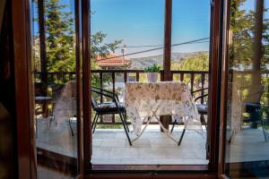 a table and chairs on a balcony with a view at Ilia house in Volos