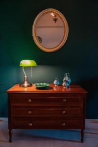 a wooden dresser with a lamp and a mirror at Ilia house in Volos +6 photos