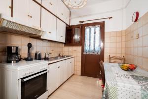 a kitchen with white cabinets and a table with a table cloth at Ilia house in Volos